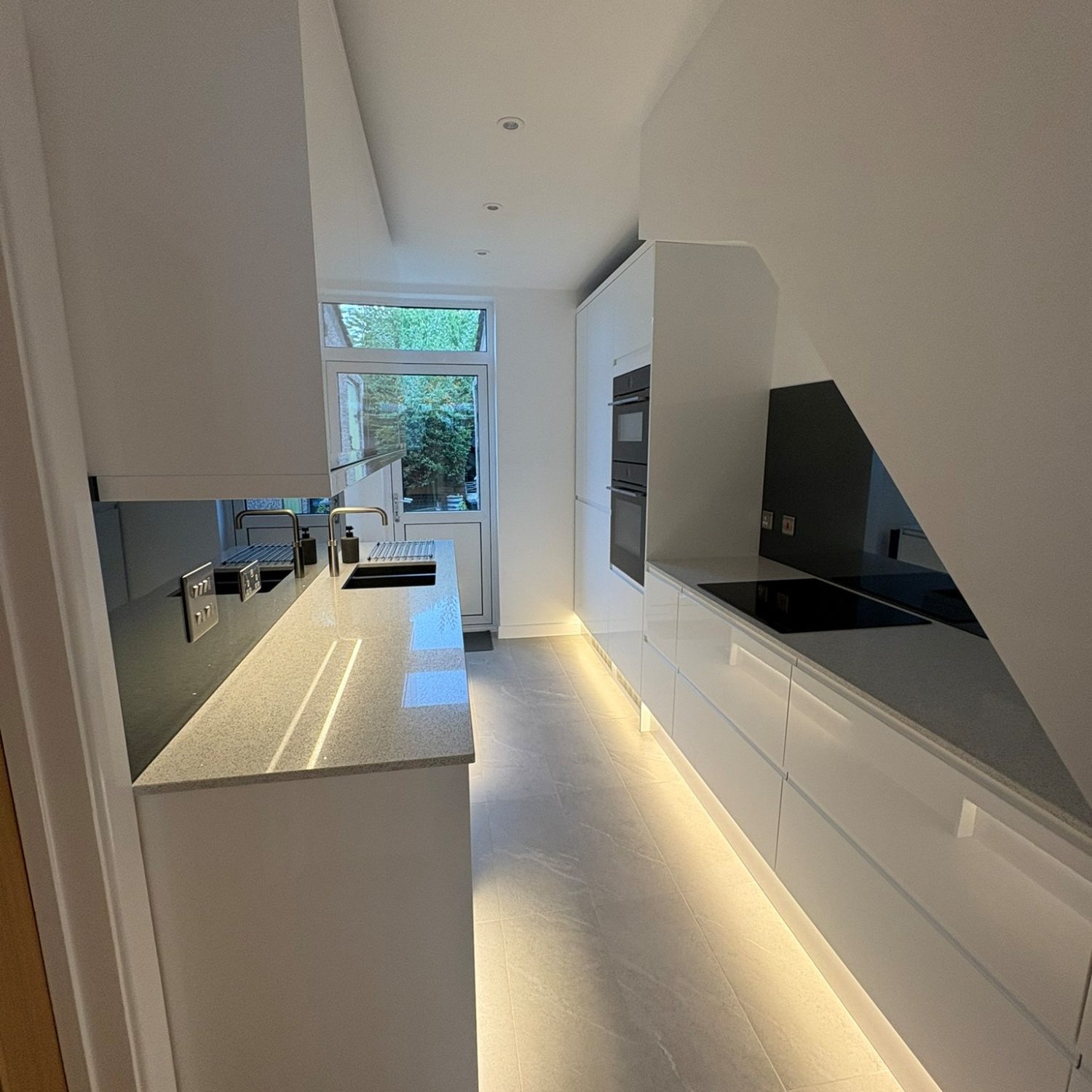 Completed Brislington kitchen with white cabinetry, quartz worktop, glass splashback and tiled floor